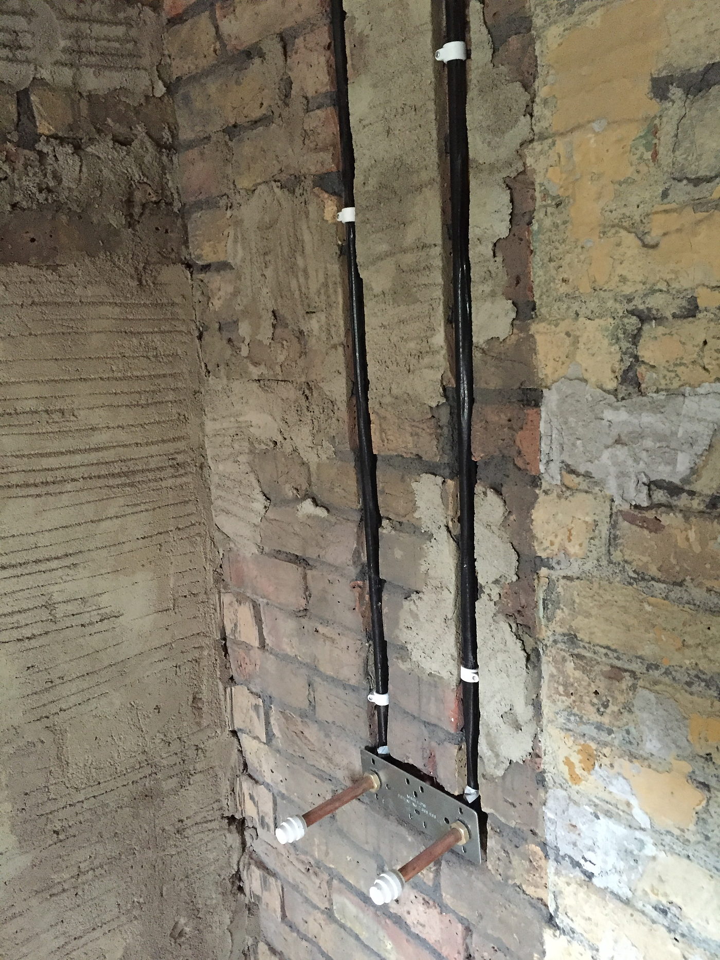 First fix pipework and cable run on bare brick during a bathroom refit