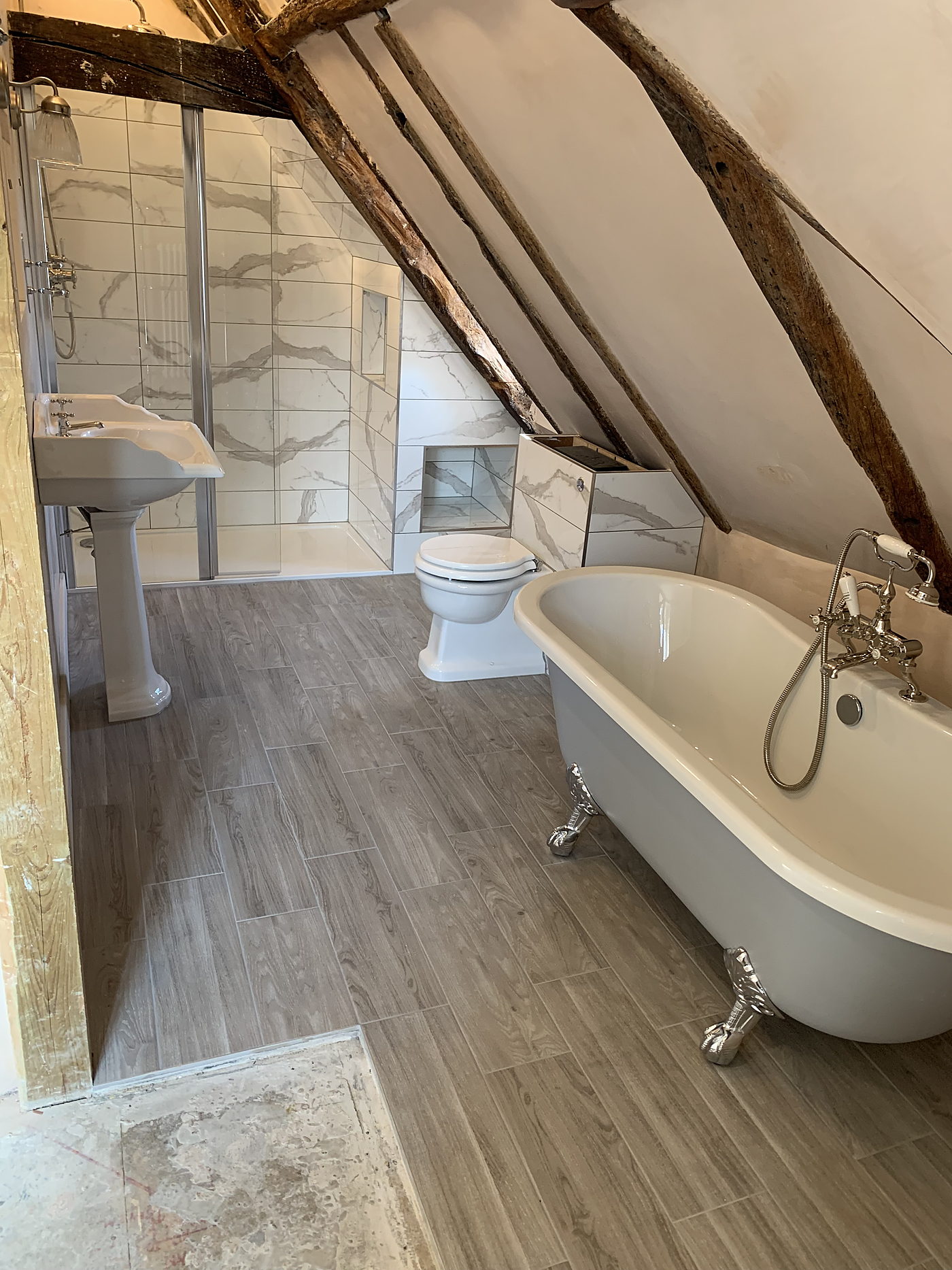 Roll top bath, basin and WC in a finished loft bathroom