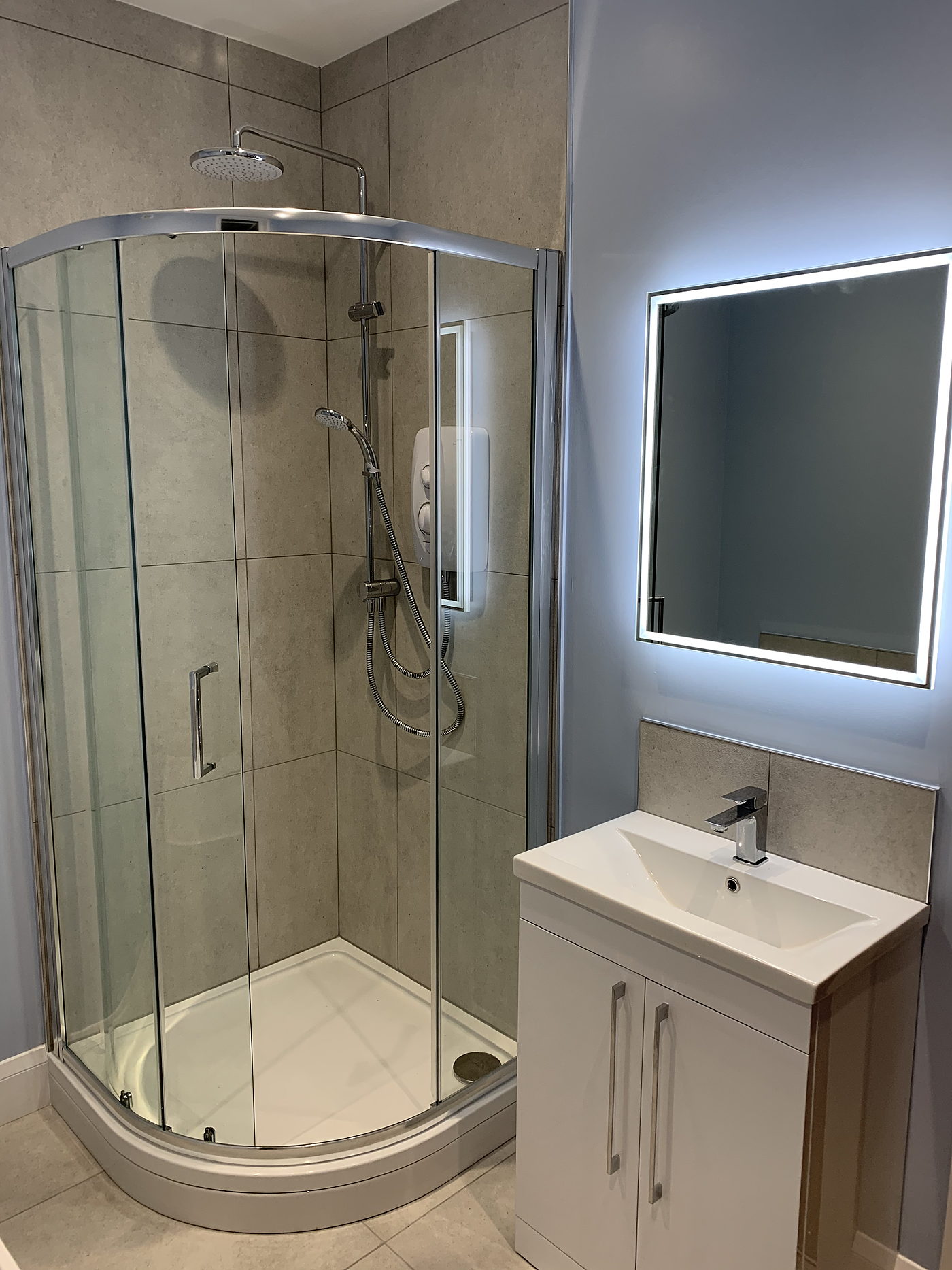 Corner shower enclosure, basin unit and backlit mirror