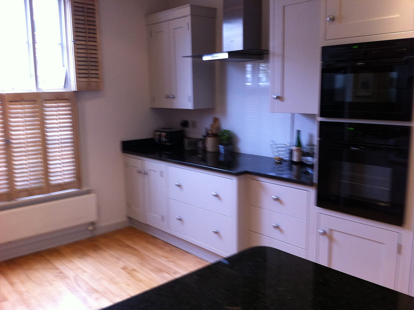 Run of kitchen units with a built in double oven and granite worktop