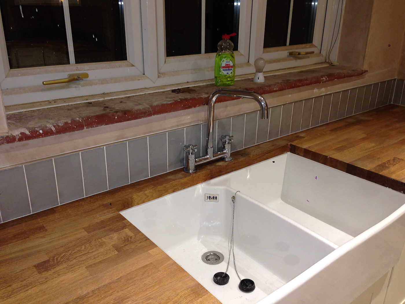 Undermount sink in an oak worktop with a tiled splashback