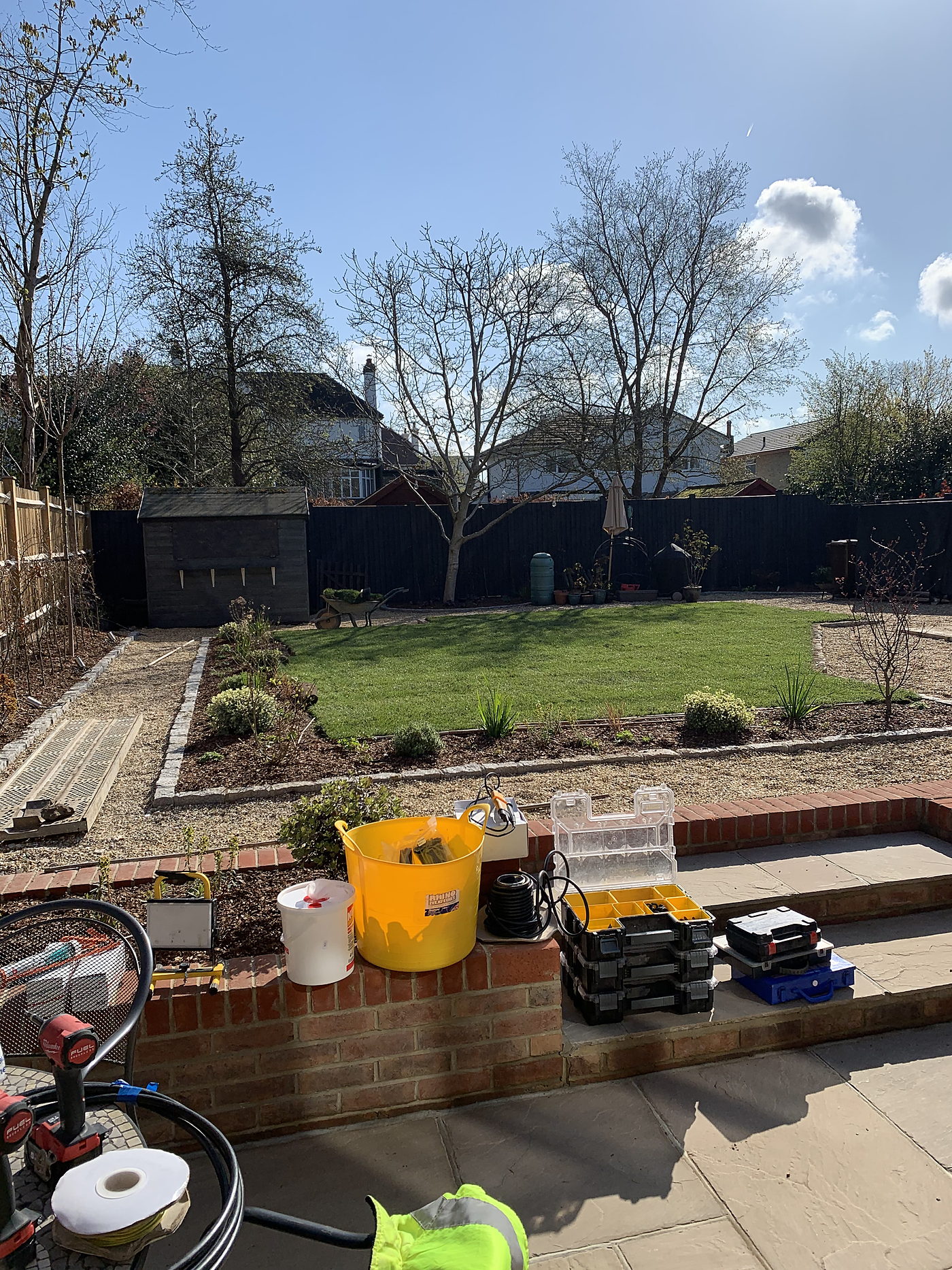 Finished garden with a raised brick bed, lawn and paved terrace