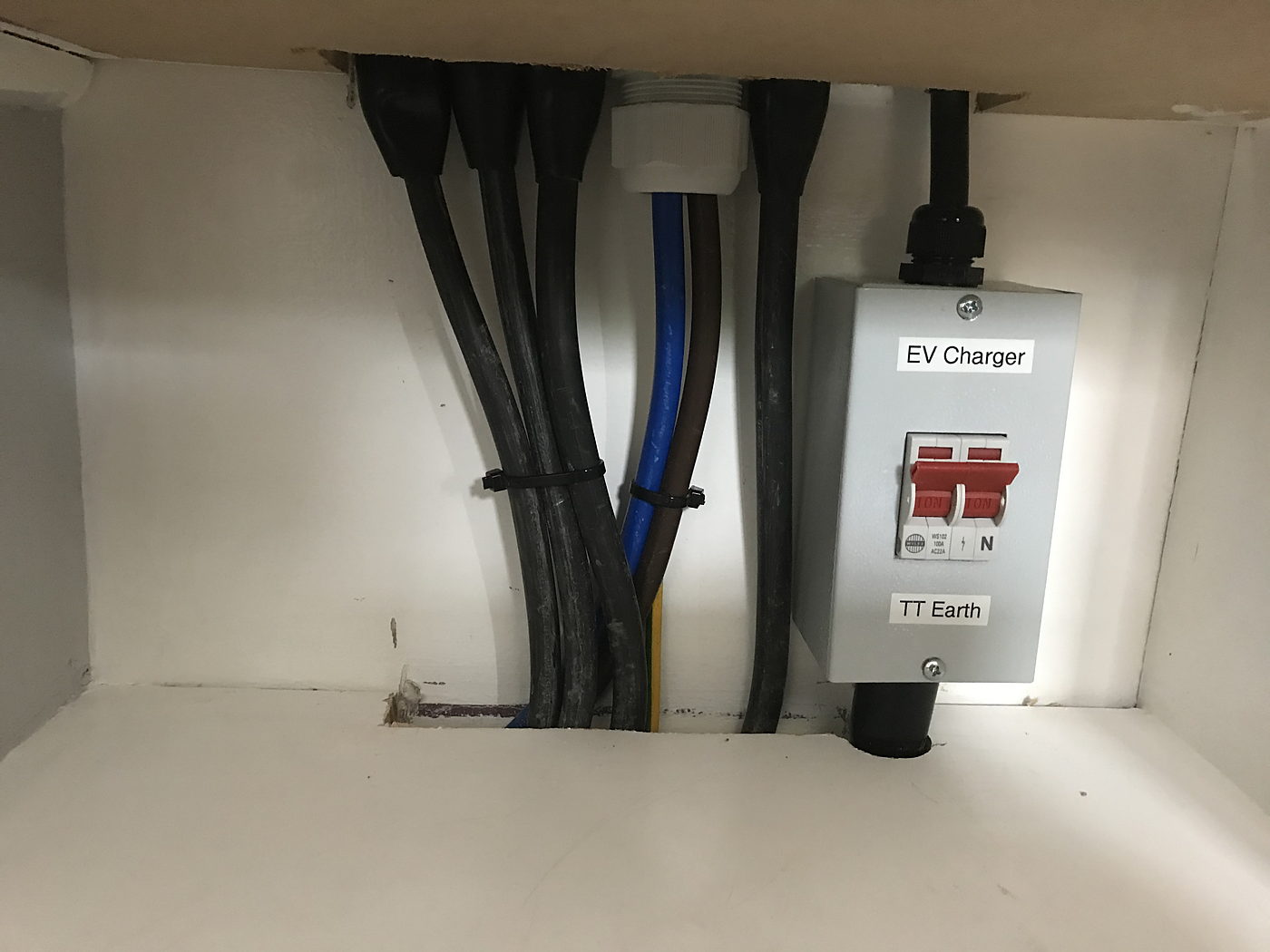 EV charger isolator and cabling fitted above a cupboard